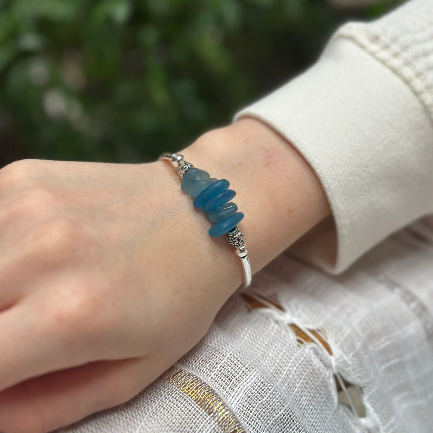 Silver bracelet with blue green nugget beads on wrist