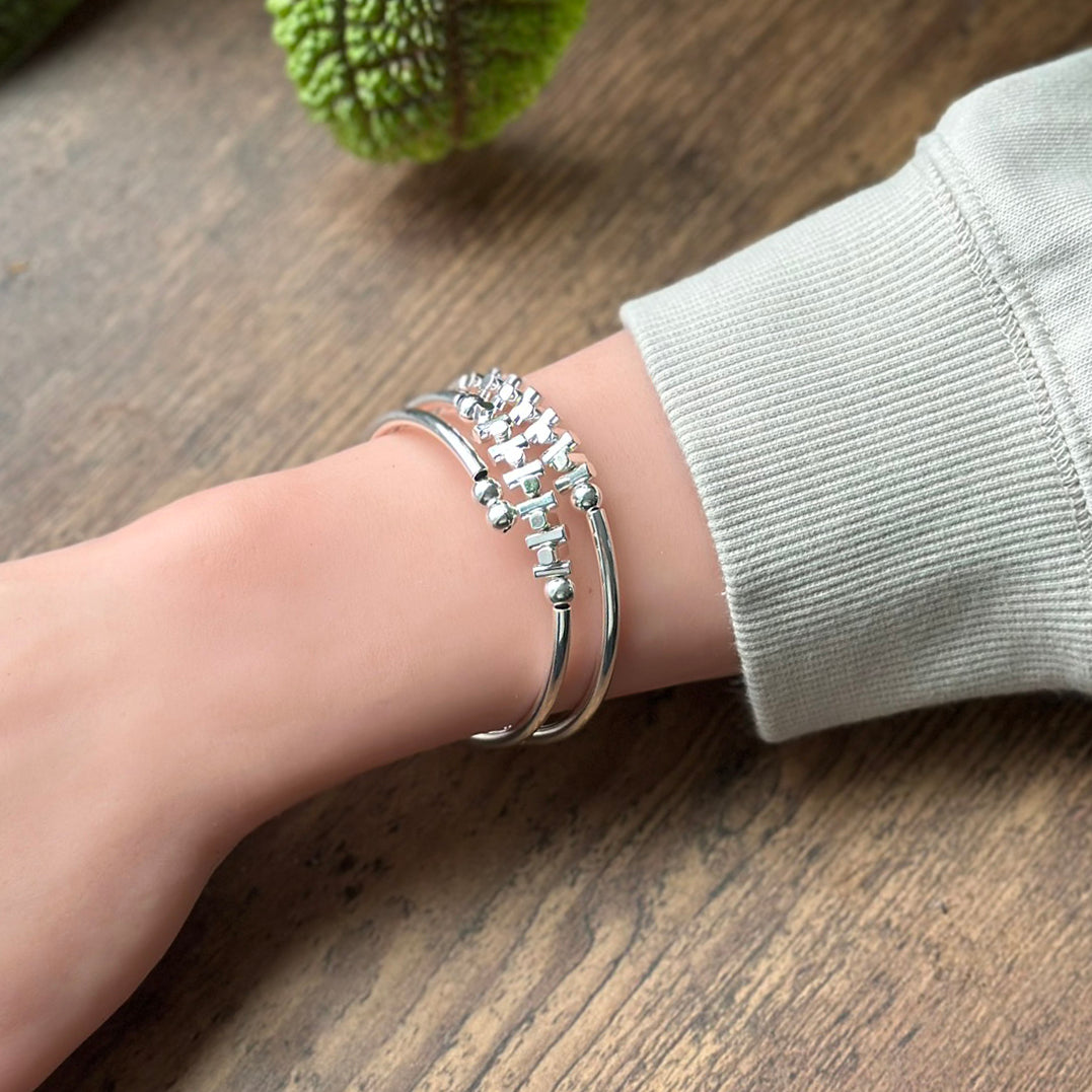 Silver fishbone bracelet on wrist with coastal style on wrist