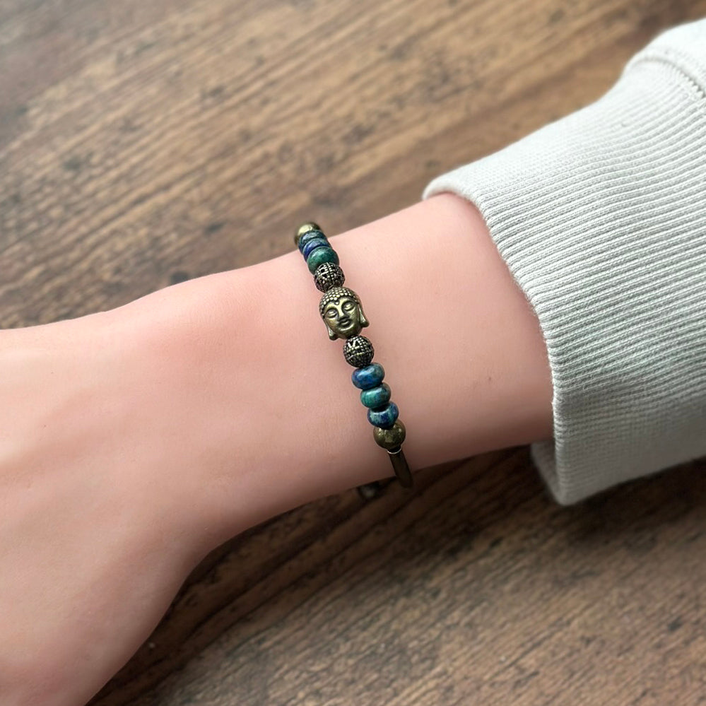 Bracelet with decorative beads on a wrist against a wooden background