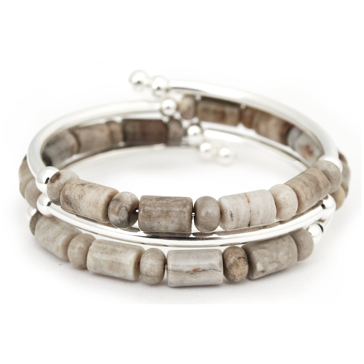 Stack of beaded bracelets with silver accents on a white background