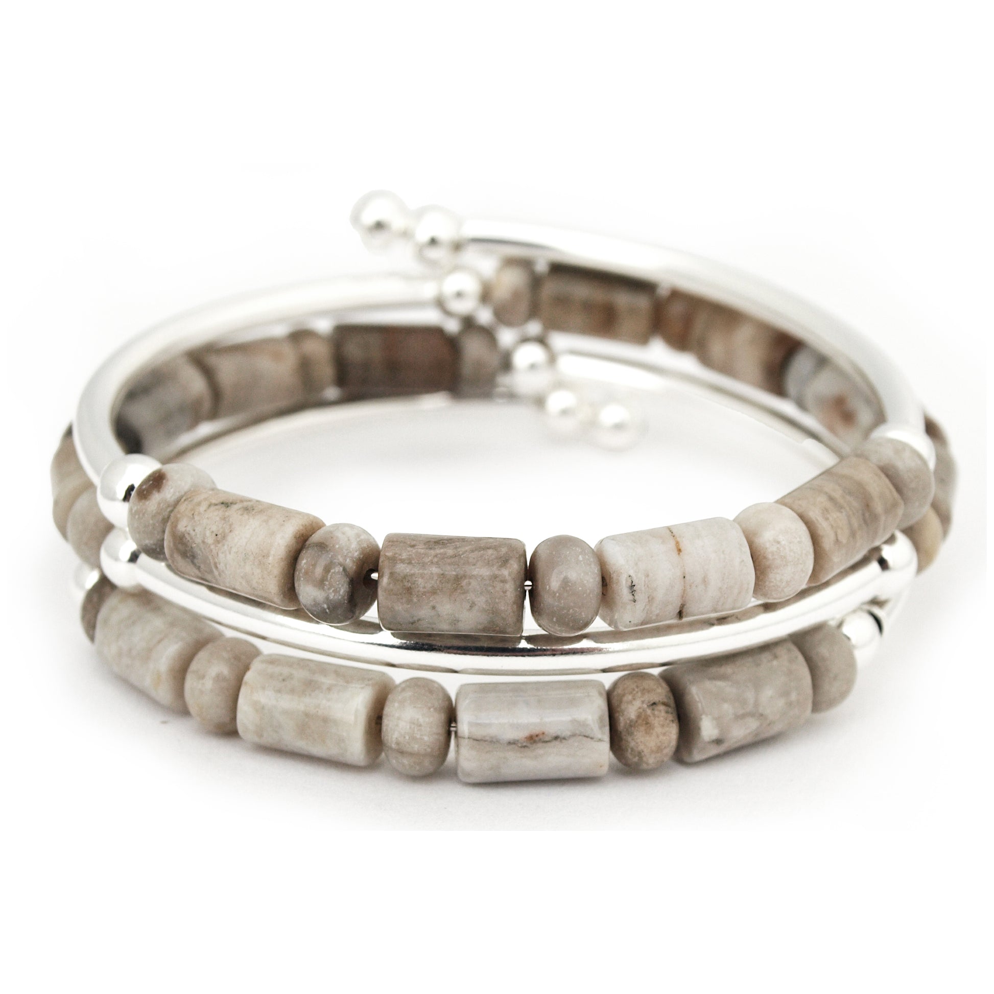 Stack of beaded bracelets with silver accents on a white background