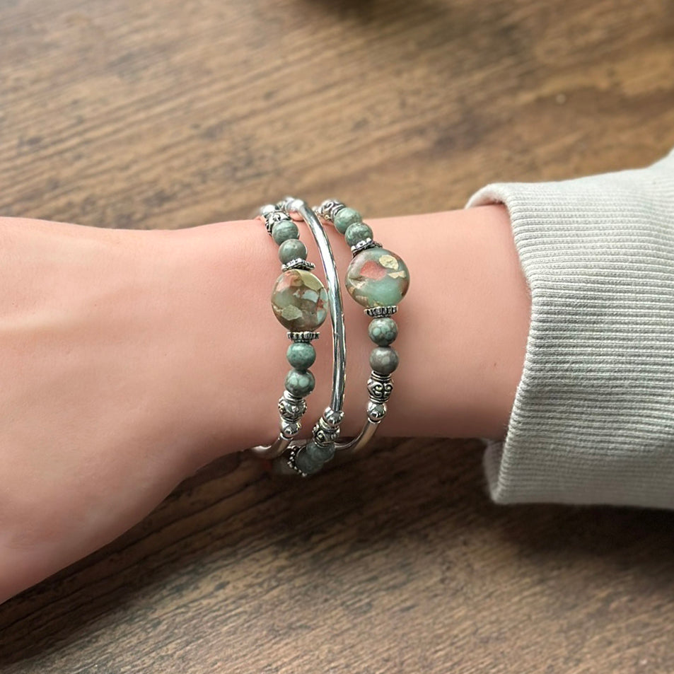 blue and brown silver bracelet on wrist on wood background