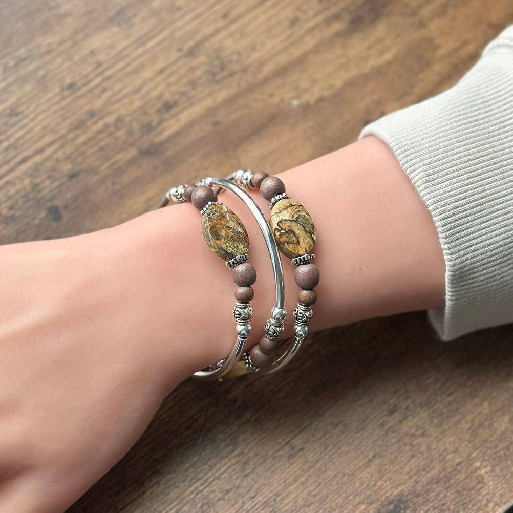 Close-up of a wrist wearing two bracelets on a wooden surface