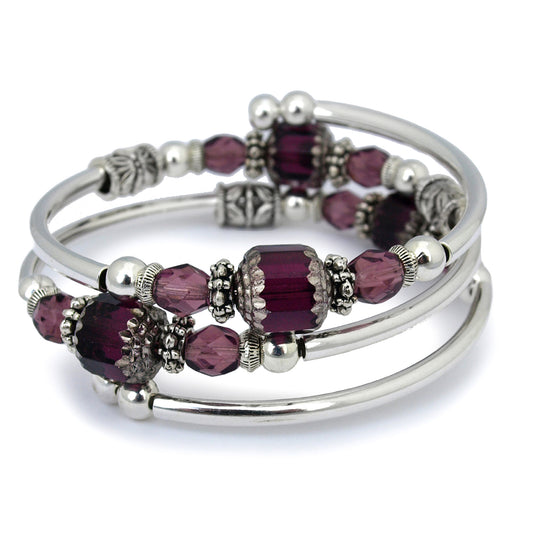 Silver bracelet with faceted purple glass beads on a white background