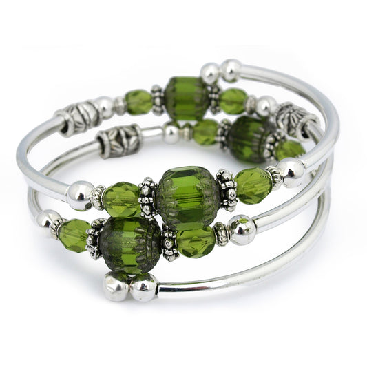 Silver bracelet with green faceted beads on a white background