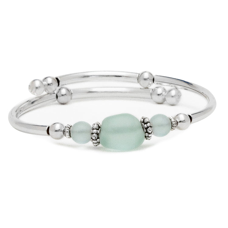 Silver bracelet with light blue beads on a white background