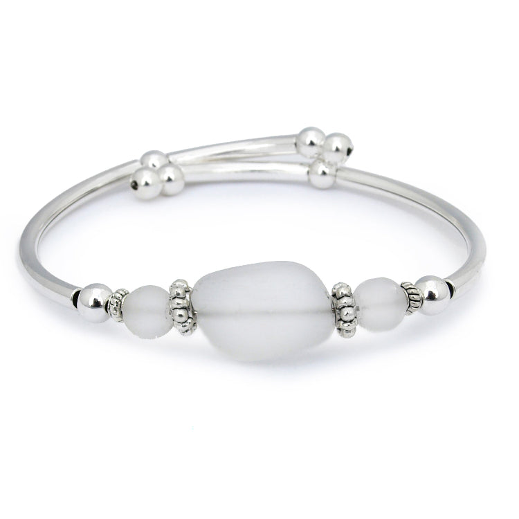 Silver bracelet with white beads on a white background