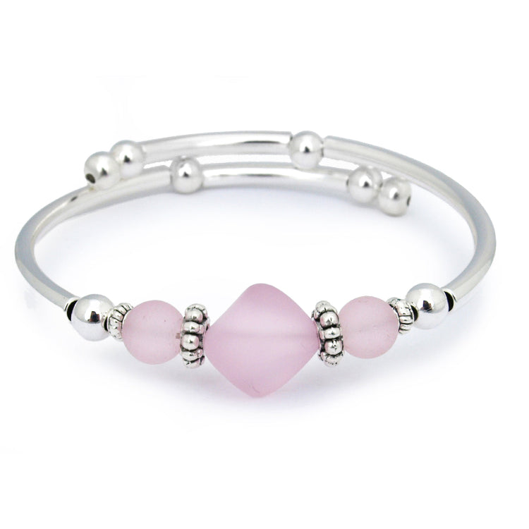 Silver bracelet with pink beads on a white background