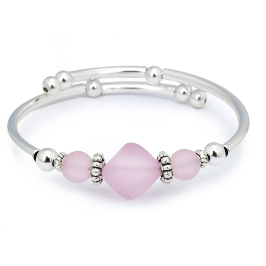 Silver bracelet with pink beads on a white background