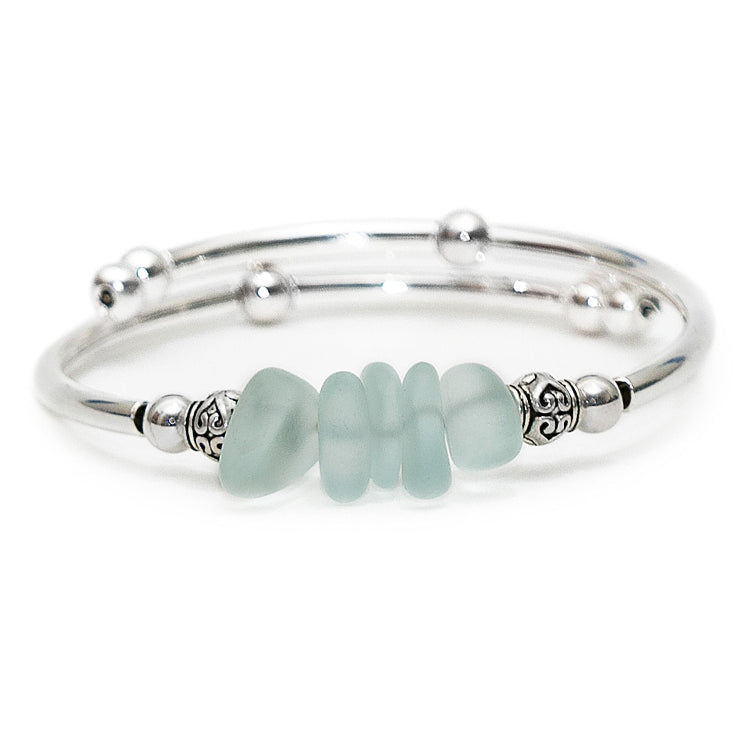 Silver bracelet with light blue beads on a white background