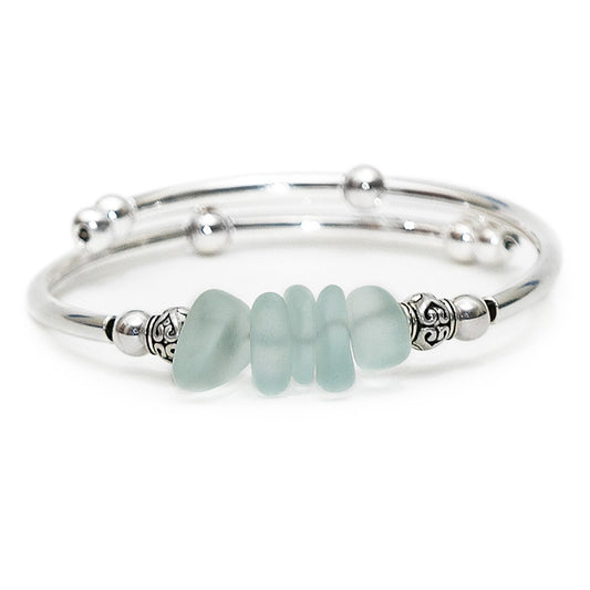 Silver bracelet with light blue beads on a white background