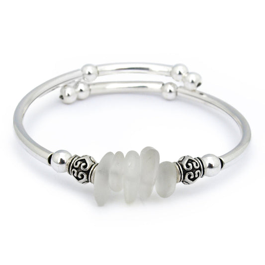 Silver bracelet with a central white bead on a white background