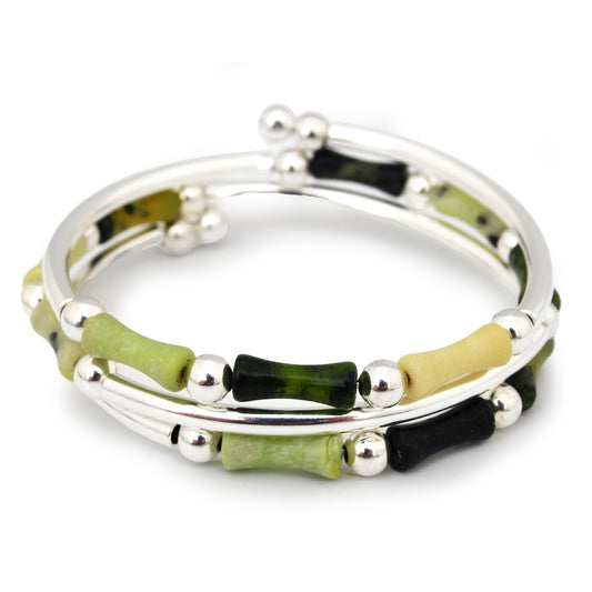 Silver bracelet with green and black beads on a white background