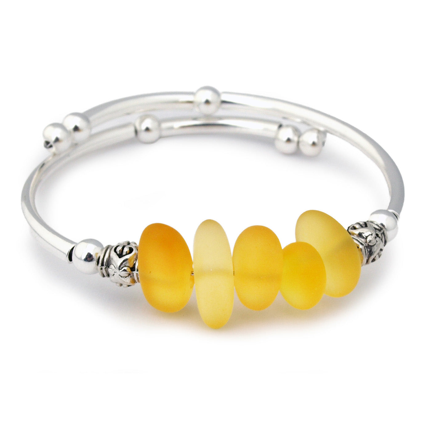 Silver bracelet with yellow sea glass beads on a white background