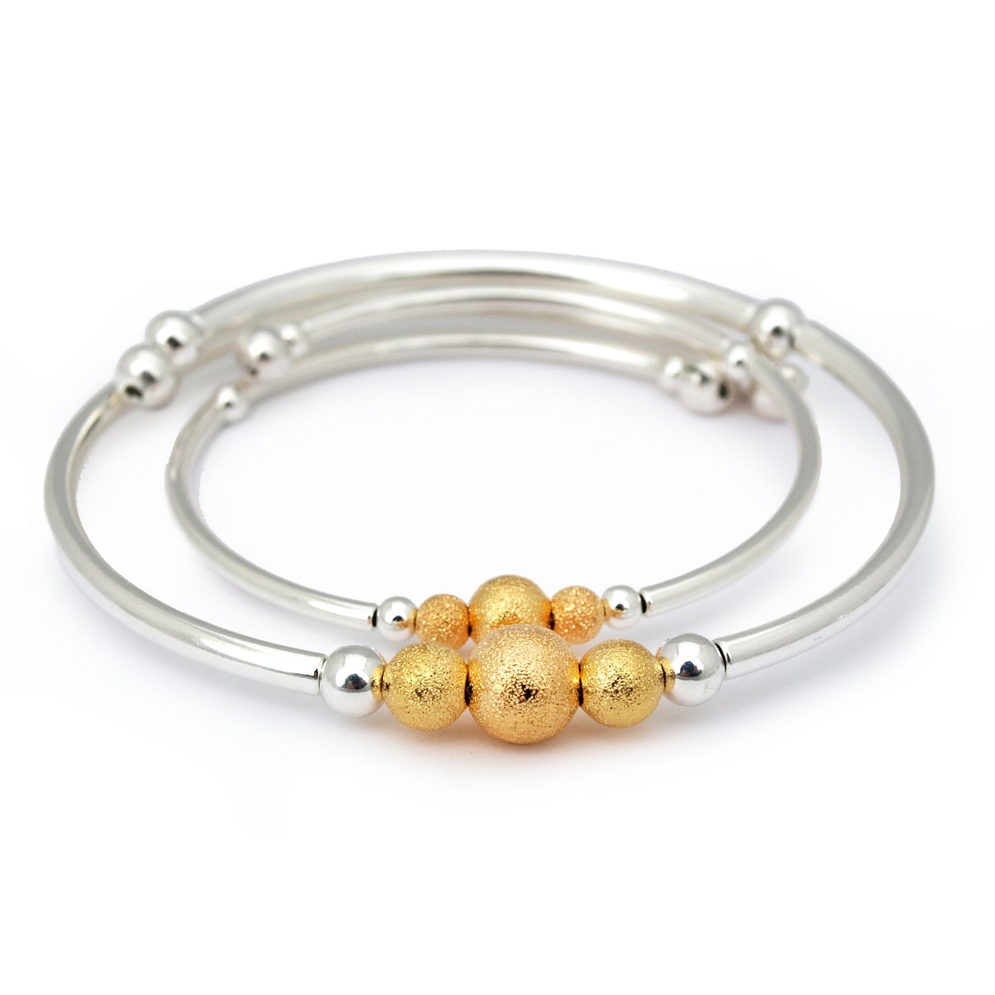 Set of silver and gold bangles on a white background