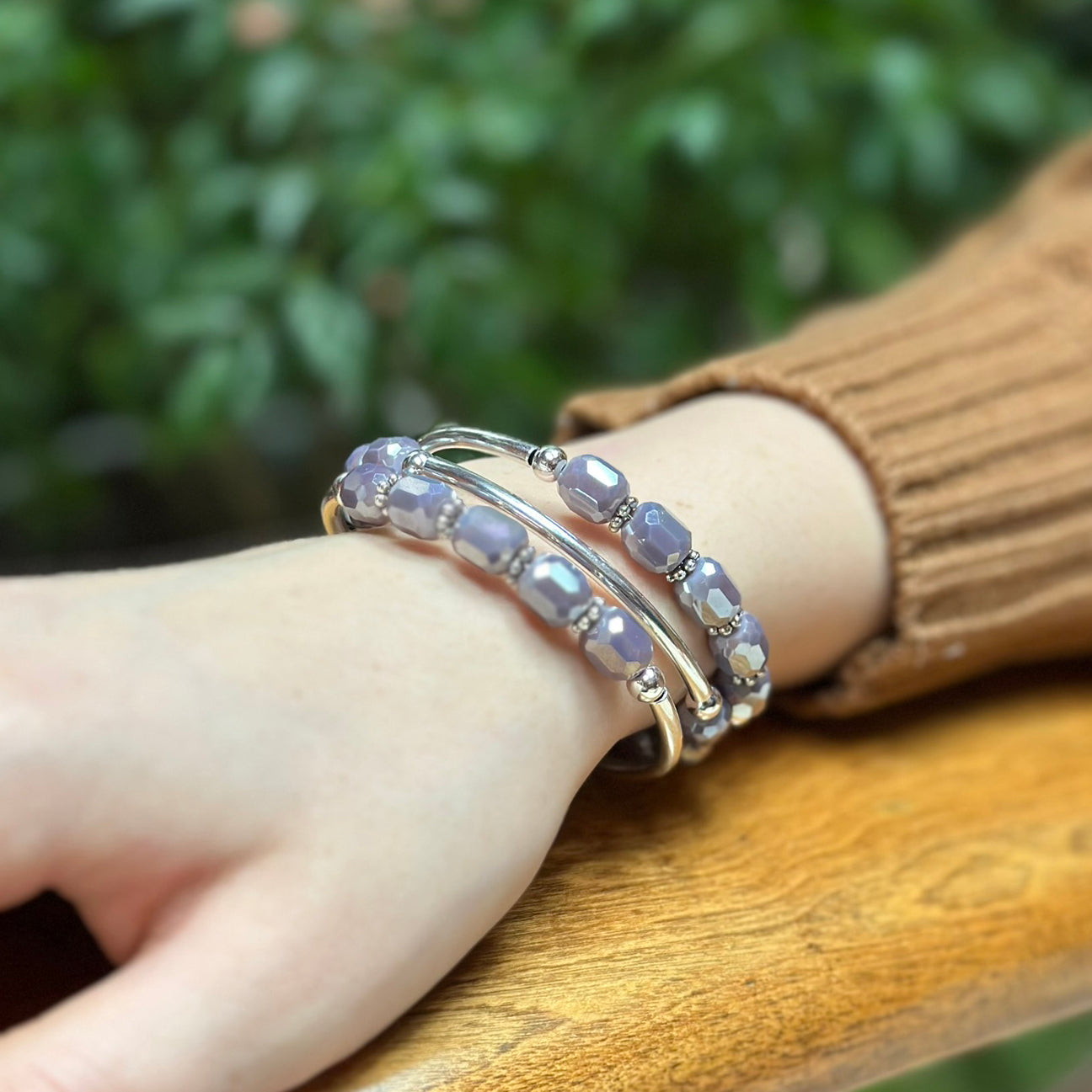 Silver bracelet with purple faceted beads on wrist