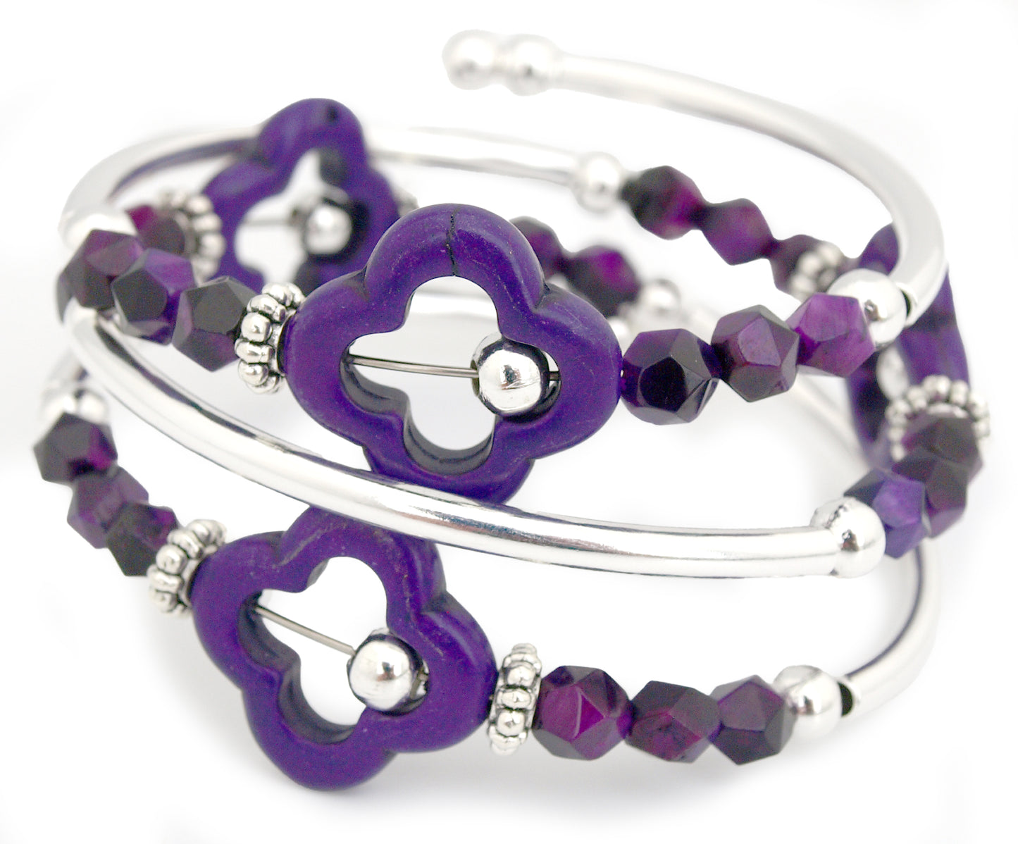 Purple beaded bracelet with clover-shaped charms on a white background