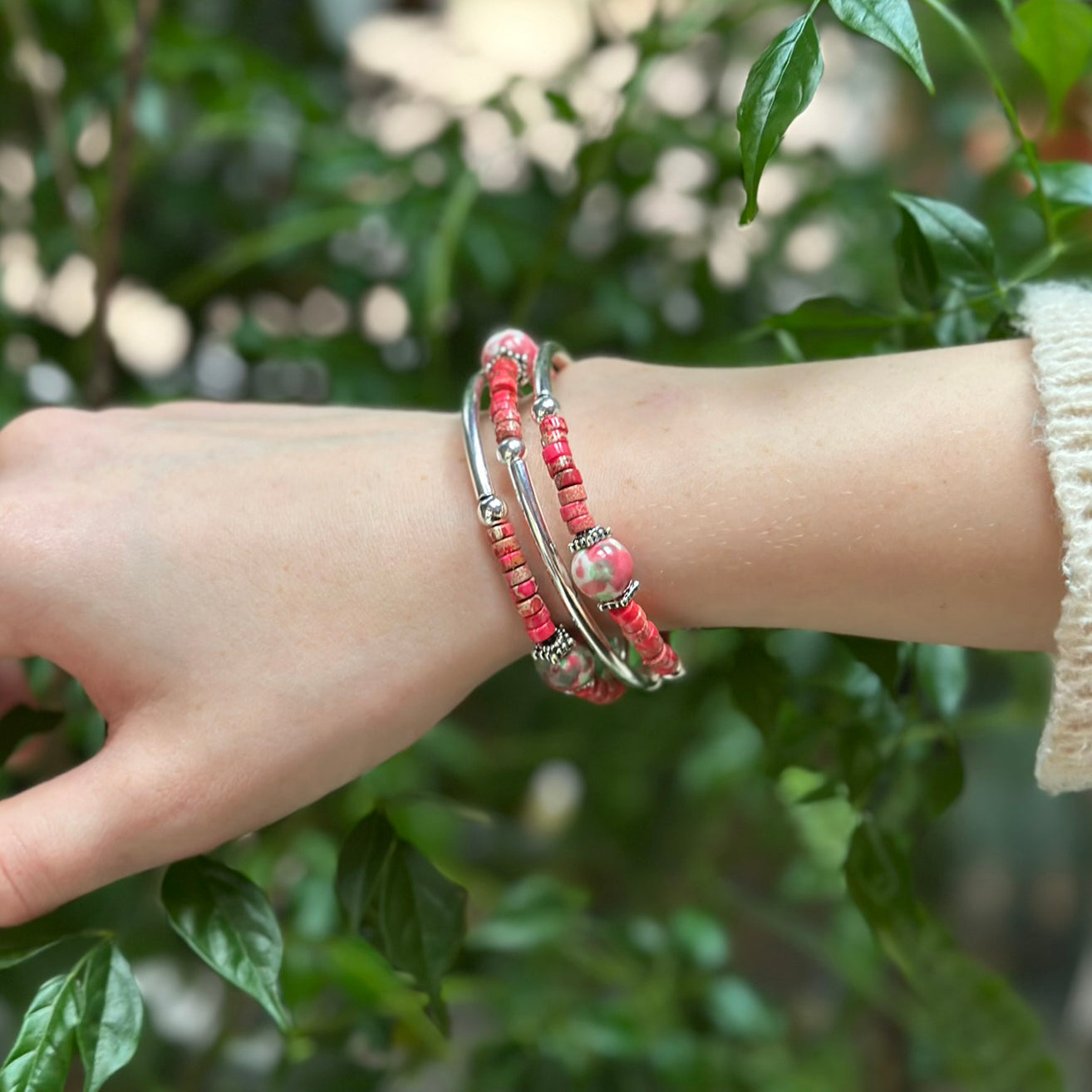 Silver wrap bracelet with coral pink beads on wrist