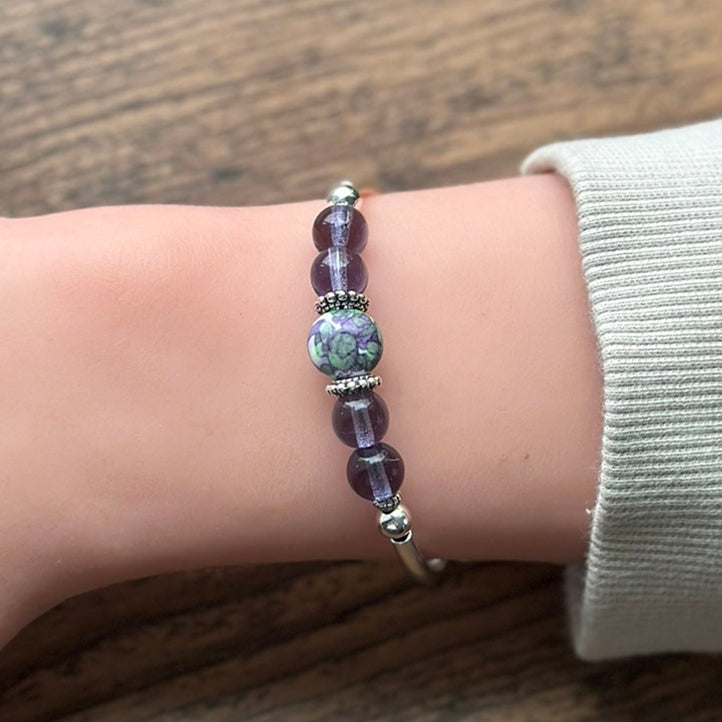 Purple glass beaded bracelet with silver on a wrist