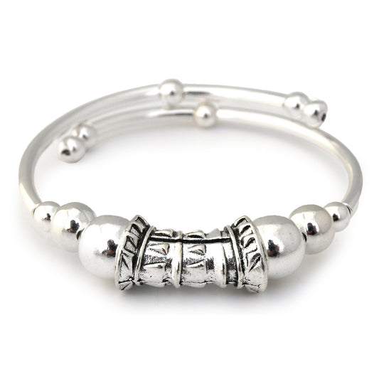Silver bracelet with decorative beads on a white background
