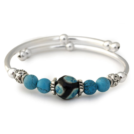 Silver bracelet with blue and black beads on a white background