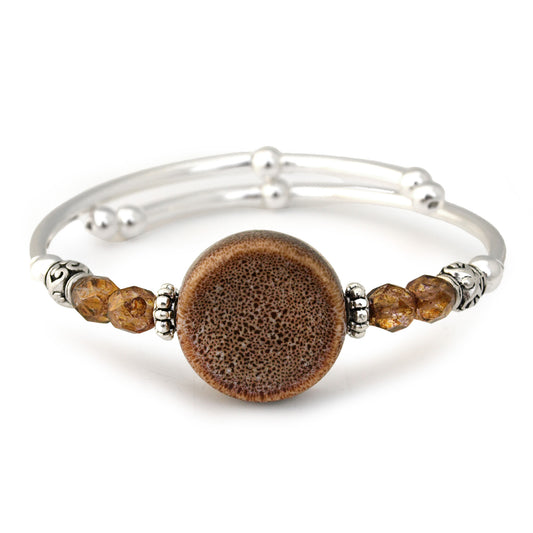 Silver bracelet with a large brown bead and smaller brown beads on a white background