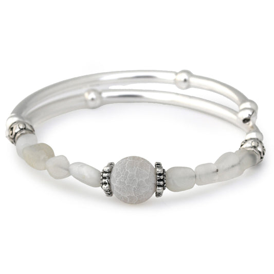 Silver bracelet with white beads on a white background