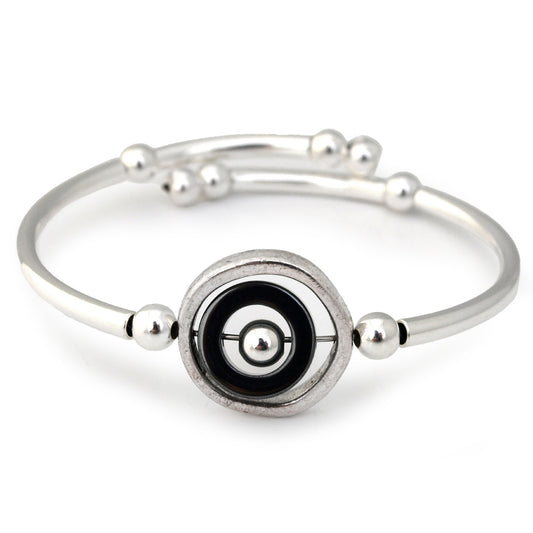 Silver bracelet with a black and silver circular design on a white background