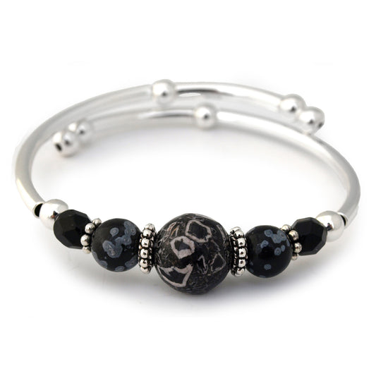 Silver bracelet with black beaded accents on a white background