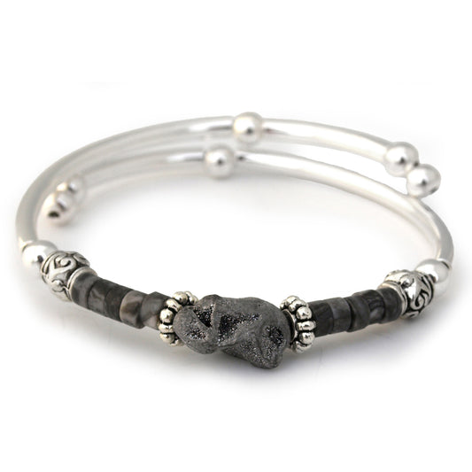 Silver bracelet with black stone beads on a white background
