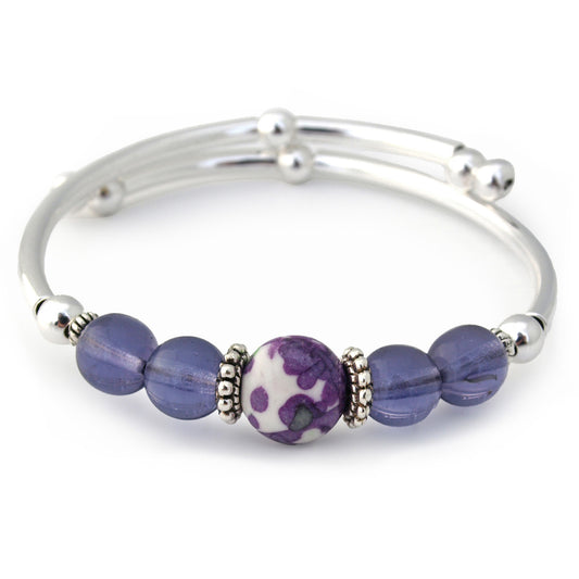 Silver bracelet with purple beads on a white background